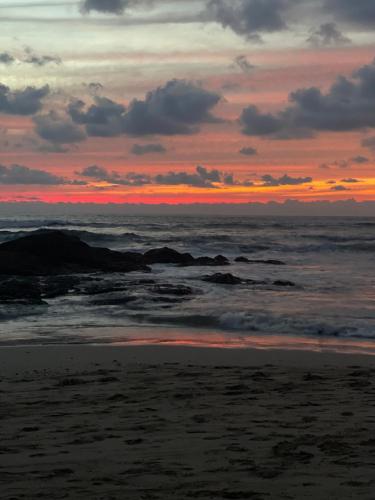 a sunset on the beach with the ocean at Casa Mari Black Stallion in Tamarindo