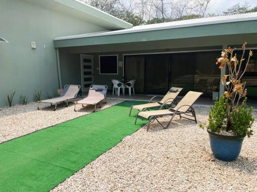 a patio with chairs and a green lawn at Casa Mari Black Stallion in Tamarindo