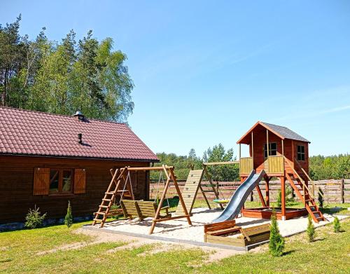 a playground with a slide and a house at Leśne Zacisze domki letniskowe in Lipnica