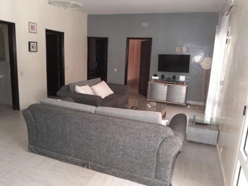 a living room with a couch and a television at Logement familial et groupe in Sali Nianiaral