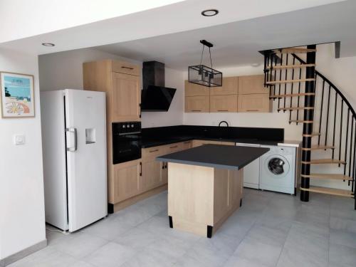 a kitchen with a white refrigerator and a staircase at Maison avec jardin Cherbourg in Cherbourg en Cotentin