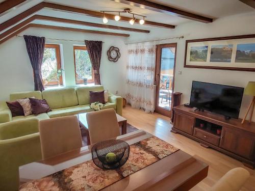 a living room with a couch and a flat screen tv at or'o apartments in Žabljak