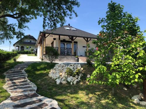 a house with a stone path in front of it at Tó Kincse Vendégház in Kustánszeg