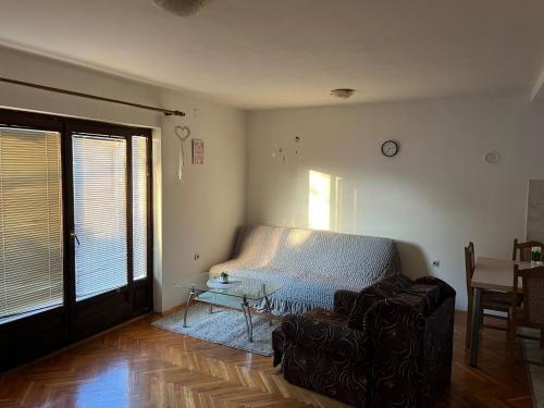 a living room with a couch and a table at GOLD Apartman in Mirijevo