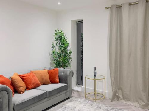 a living room with a gray couch with orange pillows at Rochester Lux Stay Townhouse 2 in Rochester