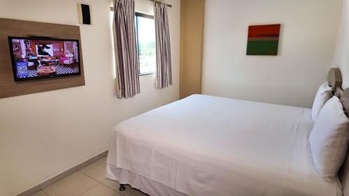a bedroom with a white bed and a window at Larison Executive by Easy Hotéis in Porto Velho