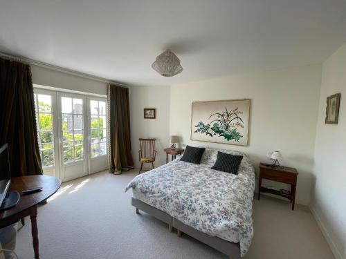 Schlafzimmer mit einem Bett, einem Schreibtisch und einem Fenster in der Unterkunft Villa Oasis in Saint-Malo