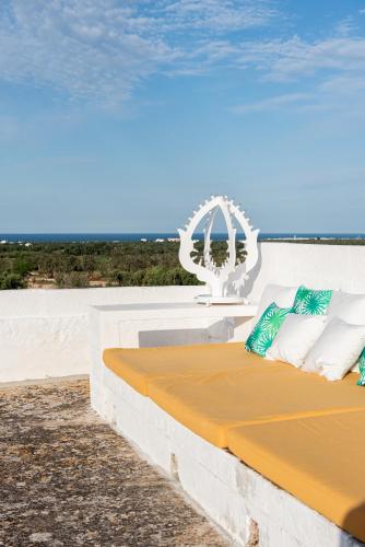 a bed sitting on the side of a wall at Masseria Borgo San Marco in Fasano