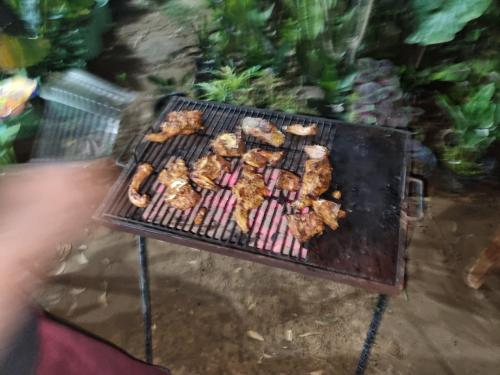a grill with chicken and other food on it at Nilaveli Guest House in Nilaveli