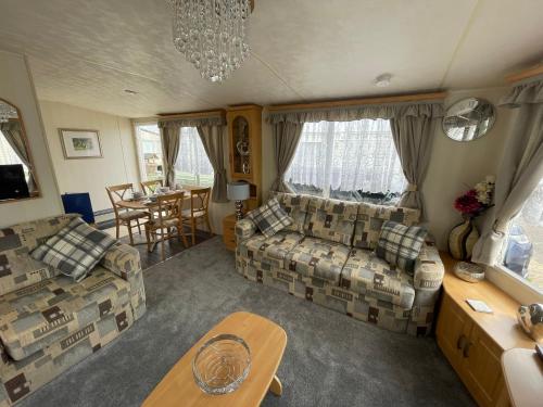 a living room with a couch and a table at Walsh's Holiday Park - Sapphire - Coastal Caravan Breaks in Lincolnshire