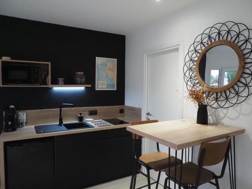 a kitchen with a sink and a counter with a mirror at Studio mer in La Plaine-sur-Mer