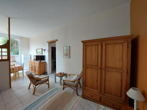 Mas Fontclaire - Sommières في سوميريس: غرفة معيشة مع خزانة وكراسي خشبية كبيرة