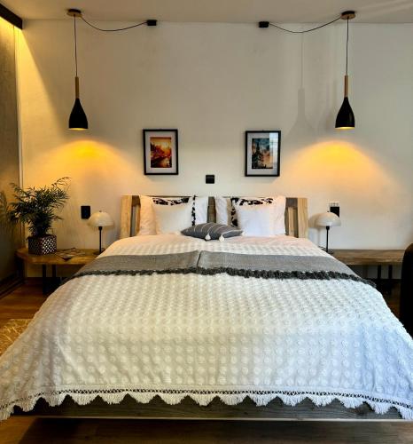 a bedroom with a large white bed with two lamps at Lovely view apartments in Sighişoara