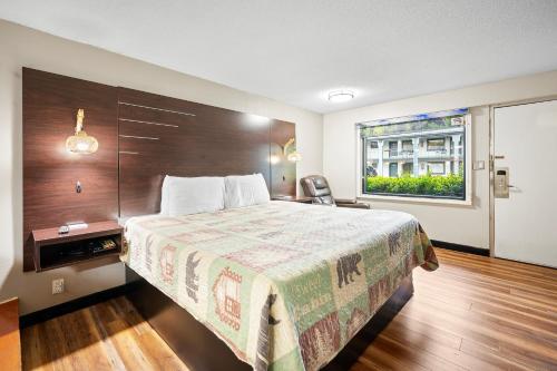 a hotel room with a bed and a window at Country Town N' Suites in Gatlinburg