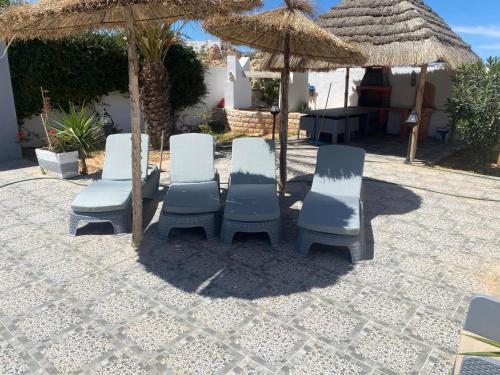 a group of chairs and umbrellas on a patio at Dar Zina in Al Maqārisah