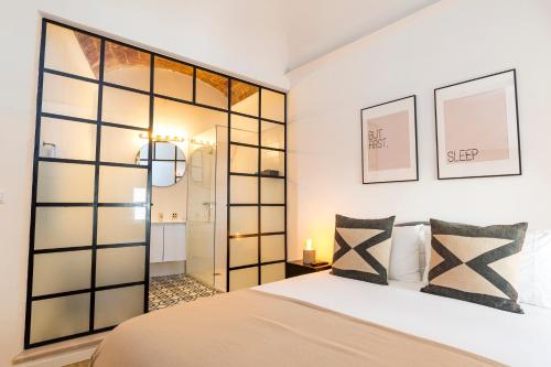 a bedroom with a bed and a glass wall at CICIOSO flats Salvador in Évora