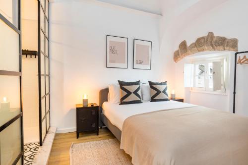 a white bedroom with a bed and a window at CICIOSO flats Salvador in Évora