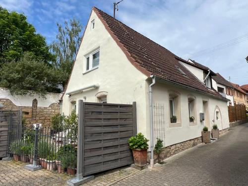 uma casa branca com um portão de madeira numa rua em Pfalzliebe.Anno 1791 em Böchingen