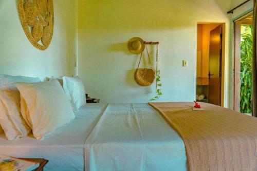 a bedroom with a large white bed in a room at Pousada Sossego in Pipa