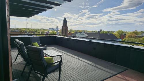 d'un balcon avec deux chaises et une table sur le toit. dans l'établissement Artisa Riia Str 22 Luxury Penthouse Apartment - 8th fl, à Tartu