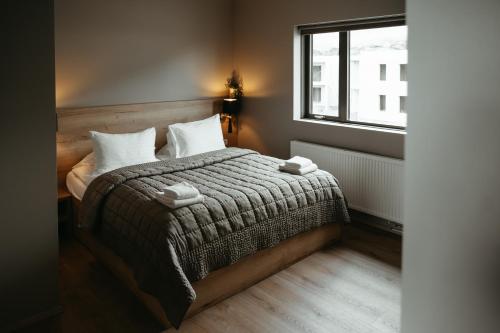 a bedroom with a bed and a window at Vík Apartments in Vík