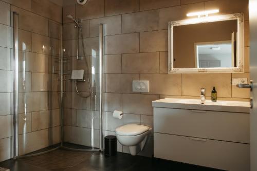 uma casa de banho com um WC, um lavatório e um chuveiro em Vík Apartments em Vík