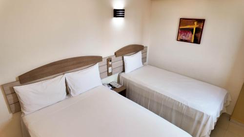 two beds sitting next to each other in a room at Larison Executive by Easy Hotéis in Porto Velho