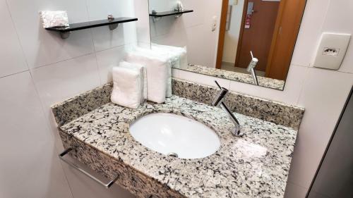 a bathroom counter with a sink and a mirror at Larison Executive by Easy Hotéis in Porto Velho