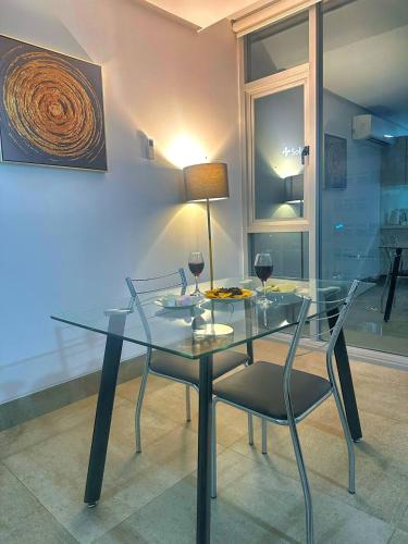 a glass table and chairs with wine glasses on it at Airbnb Guayaquil, Mall del Sol, Piso alto in Guayaquil