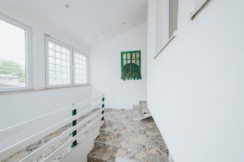 a staircase in a house with white walls and windows at Old Town Residence Rooms in Sarajevo