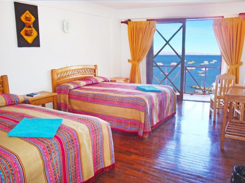 a hotel room with two beds and a balcony at HOTEL ESTELAR del TITICACA in Copacabana