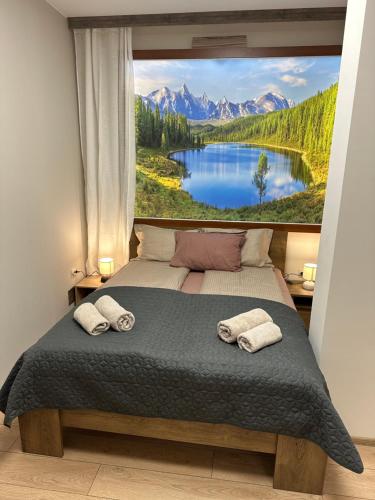 een slaapkamer met een grote foto van een meer en bergen bij Apart-Hotel Crown Bansko 2 in Bansko