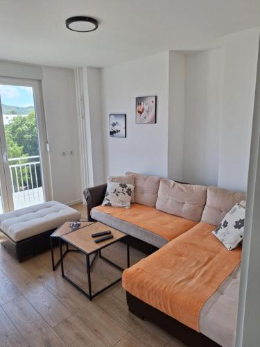 een woonkamer met een bank en een tafel bij Relax Lux apartment Nis in Niš