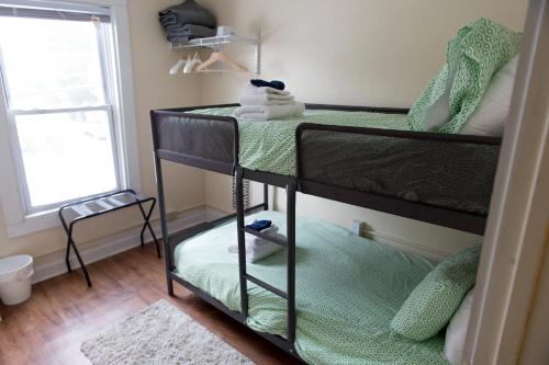 two bunk beds in a room with a window at My Cousins Place in Burlington