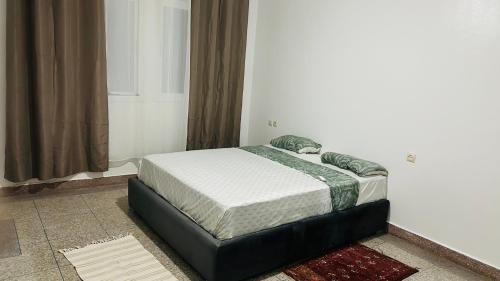 een klein bed in een kamer met een raam bij Grand appartement avec rooftop in Monte ʼArrouit