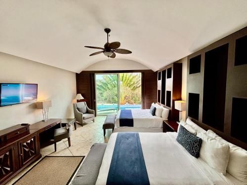 a hotel room with two beds and a ceiling fan at Hotel Hacienda San Pancho in San Francisco
