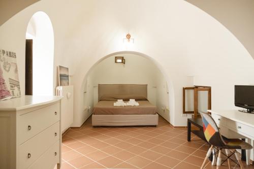 um quarto com uma cama e uma secretária num quarto em Trulli Minerva em Noci