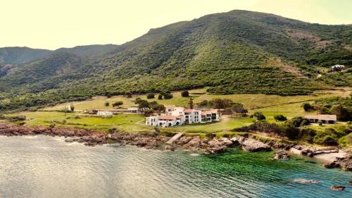 an aerial view of a house on a hill next to the water at Résidence Punta paliagi in Calcatoggio