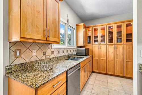 a kitchen with wooden cabinets and granite counter tops at The Sun Dial - 827 in Siesta Key