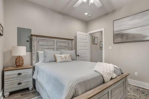 une chambre avec un grand lit avec une tête de lit en bois dans l'établissement Waveland Beach Cottage 215, à Waveland