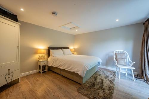 - une chambre avec un lit et une chaise dans l'établissement Quiet Self contained Cottage near Delamere Forest, à Cuddington