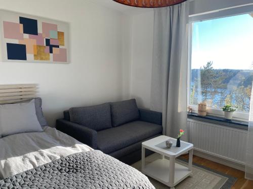 a bedroom with a bed and a couch and a window at Sand in Nynäshamn