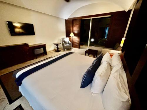 a bedroom with a large white bed with pillows at Hotel Hacienda San Pancho in San Francisco