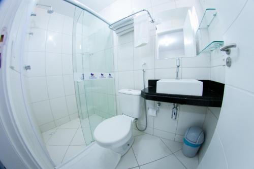 y baño con aseo, lavabo y ducha. en Hotel Ilha Costeira, en São Luís