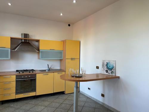 une cuisine avec des armoires jaunes et une table en bois dans l'établissement Villa Fiore, à Nettuno