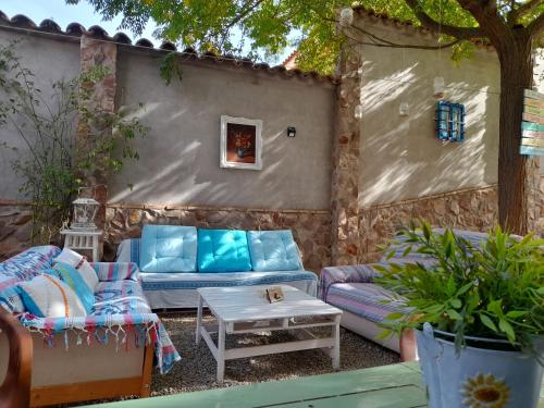 CamuñasにあるVIVENCIAS casa rural para 10 personasのソファ、テーブル、木々が並ぶパティオ