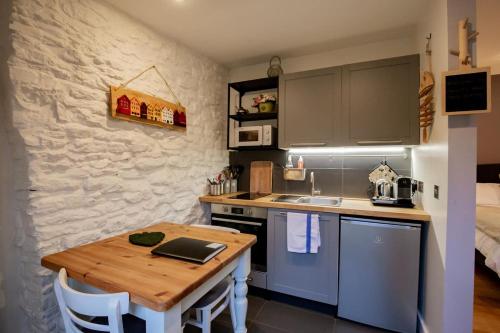 a small kitchen with a wooden table in a room at Cosy Little Barn near Bath in Rode