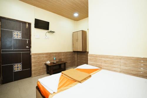 Un dormitorio con una cama y una mesa pequeña. en Hotel Sai Parikrama, en Bombay