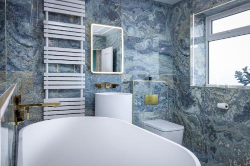 a bathroom with a sink and a toilet and a mirror at Swish Luxury Holiday Apartments in Blackpool