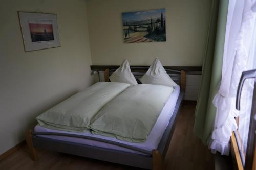 Goldach的住宿－Hotel Linde Goldach，一间卧室配有带白色床单和枕头的床。